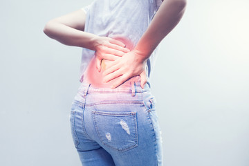 Portrait of young woman touching her back with pained expression, suffering from backache after long working hours, Healthy concept.