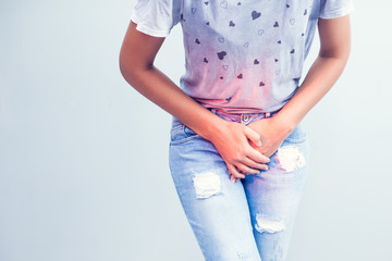 Young sick woman with hands holding pressing her crotch lower abdomen. Medical or gynecological problems, healthcare concept - obrazy, fototapety, plakaty
