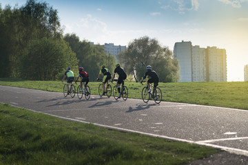 group of cyclist at professional race on the special asphalt road under the summer sunset - 205733246