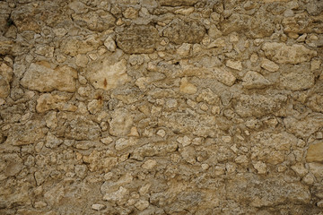 Alte Burgmauer mit unregelmäßigen gelben Sandsteinelementen
