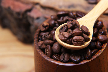 close-up various kinds of coffee beans scattered on a wooden background, ground coffee, wooden spoon empty space for text, macro, set