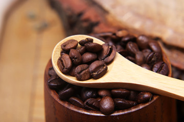 close-up various kinds of coffee beans scattered on a wooden background, ground coffee, wooden spoon empty space for text, macro, set