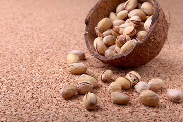 handmade bowl of coconut with pistachios on a wooden table. Close-up.