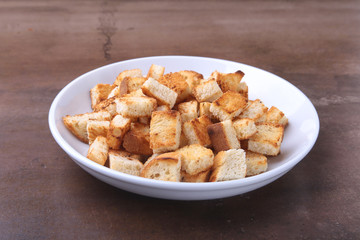 Delicious crispy croutons, crumbs of bread in white plate. ready for cooking.