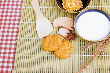 cereal cookies milk in bowl Cornflakes spices on wooden bamboo and copy space for text. top view
