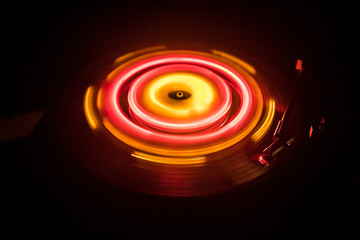 Turntable playing vinyl with glowing abstract lines concept on dark background