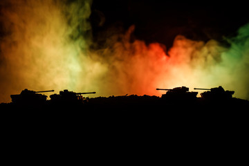 Fototapeta na wymiar War Concept. Military silhouettes fighting scene on war fog sky background, World War German Tanks Silhouettes Below Cloudy Skyline At night. Attack scene. Armored vehicles. Tanks battle. Close up