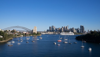Fototapeta na wymiar view of city in Sydney with waterfront and cruise on harbour, in clear blue sky day