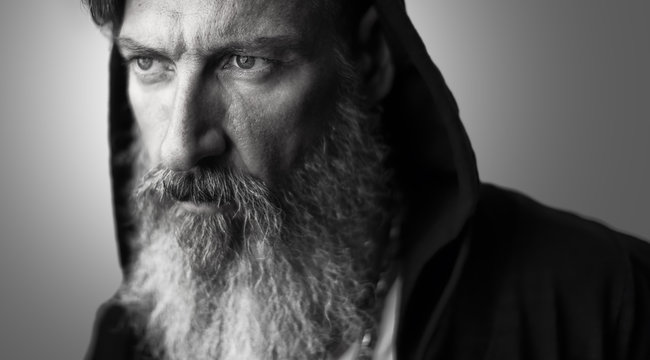 Portrait eines attraktiven Mannes mit einem Bart und Kaputze