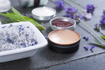 beauty products and lavender on black wooden table