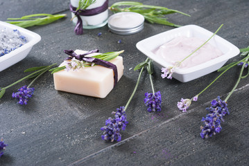 beauty products and lavender on black wooden table