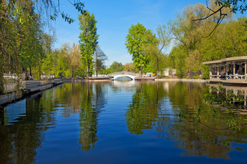 Fototapeta na wymiar City park with a bridge and a pond.