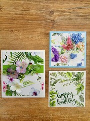 Scrapbooking - three handmade cards on a wooden background. A series of postcards with exotic prints - beautiful plants and flowers watercolor style