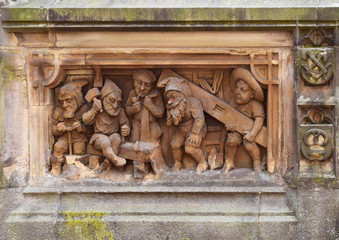 Relief gnomes carpenters. Fragment of the Dwarf Fountain in Cologne. The fountain was created in 1899, by sculptors, father and son, Edmund and Henry Renard. Cologne, Germany, August 2017.
