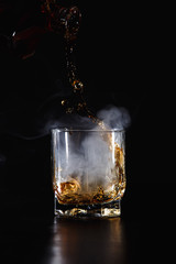 a glass of whiskey, rum or alcohol  on a dark background
