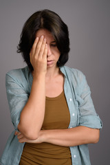 Young beautiful woman against gray background