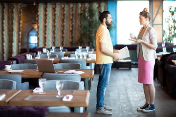 Young creative designers in casualwear having conversation in cafe about new trends