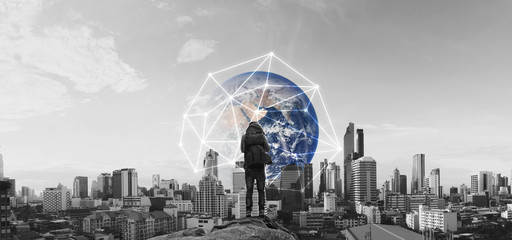a man with backpack standing on the rock, and city view with global network connection. Internet network, global communication and travel business concept. Element of this image are furnished by NASA