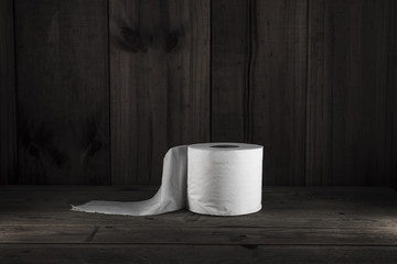 Toilet paper placed on wooden floor.