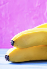 Raw bananas on summer pink blue background, selective focus