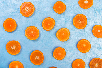 Fresh orange slices on blue background, top view