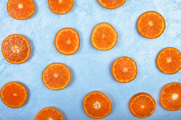 Fresh orange slices on blue background, top view