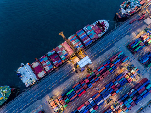 Aerial view of international port with Crane loading containers in Container ship in import export and business logistics with crane and Shipping cargo.