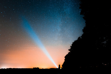 Taschenlampe leuchtet in Sternenhimmel