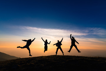 Fototapeta na wymiar silhouette of friends jumping in sunset for happiness,fun and team work concept