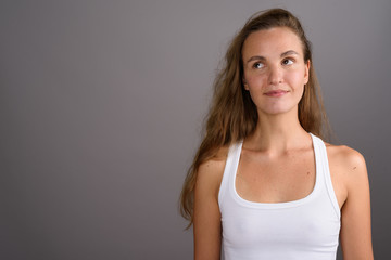 Obraz premium Young beautiful woman with long blond hair against gray backgrou