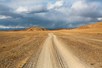 Fototapeta na wymiar Road through the steppe and mountains of Western Mongolia.