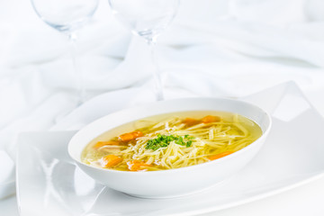 Lunch setting table with chicken or beef soup with noodles carrot and herbs