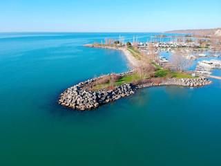 Fototapeta premium Aerial view of boats and beautiful island at sunrise in America. Colorful landscape with boats in marina bay sea city. Top view of harbour with yacht and sailboat. Beginning of summer concept.