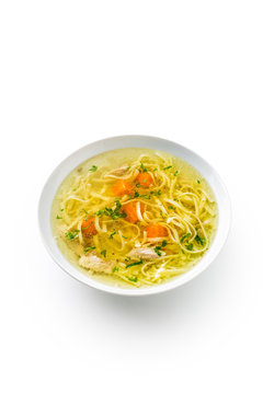 Chocken or beef soup with noodles carrot and parsley herb isolated on white