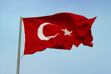 Wavy Turkish Flag, blue open sky background.