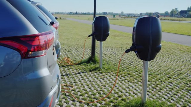 : Several electric vehicles are charged on a street charger