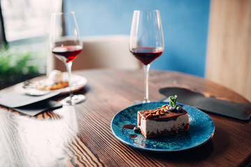 Dessert on plate and red wine in glass, nobody