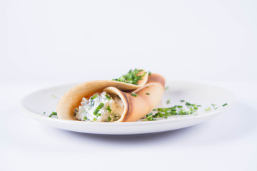 Pancake with cottage cheese and chives decorated with basil