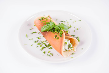 Fototapeta na wymiar Pancake with cottage cheese and chives decorated with basil