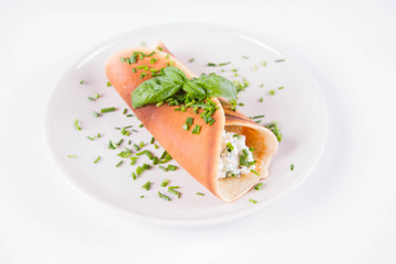 Pancake with cottage cheese and chives decorated with basil