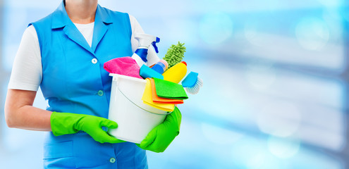 Female cleaner holding a bucket with cleaning supplies