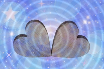 Two wooden hearts on a blue background with stars