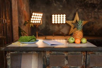Loft minimalistic kitchen interior photo with retro design table and fruits on it. Old fashioned brick wall background lighted with