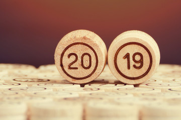 Number is 2019 against the black background, wooden kegs of lotto. New Year. Close up