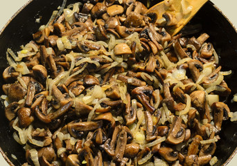 Juicy tasty fried mushrooms with onions in a frying pan