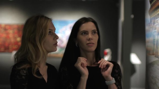 two women in a dark gallery picture