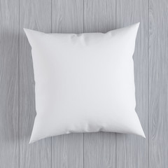 Blank white soft square pillow on a wooden floor, 3D render