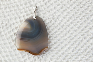 Gray beige pendants on white crochet doily background