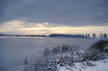 frozen lake in winter at sunset