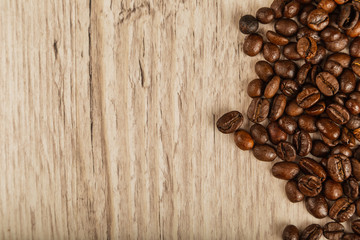 Grains of coffee on a wooden background in large quantities